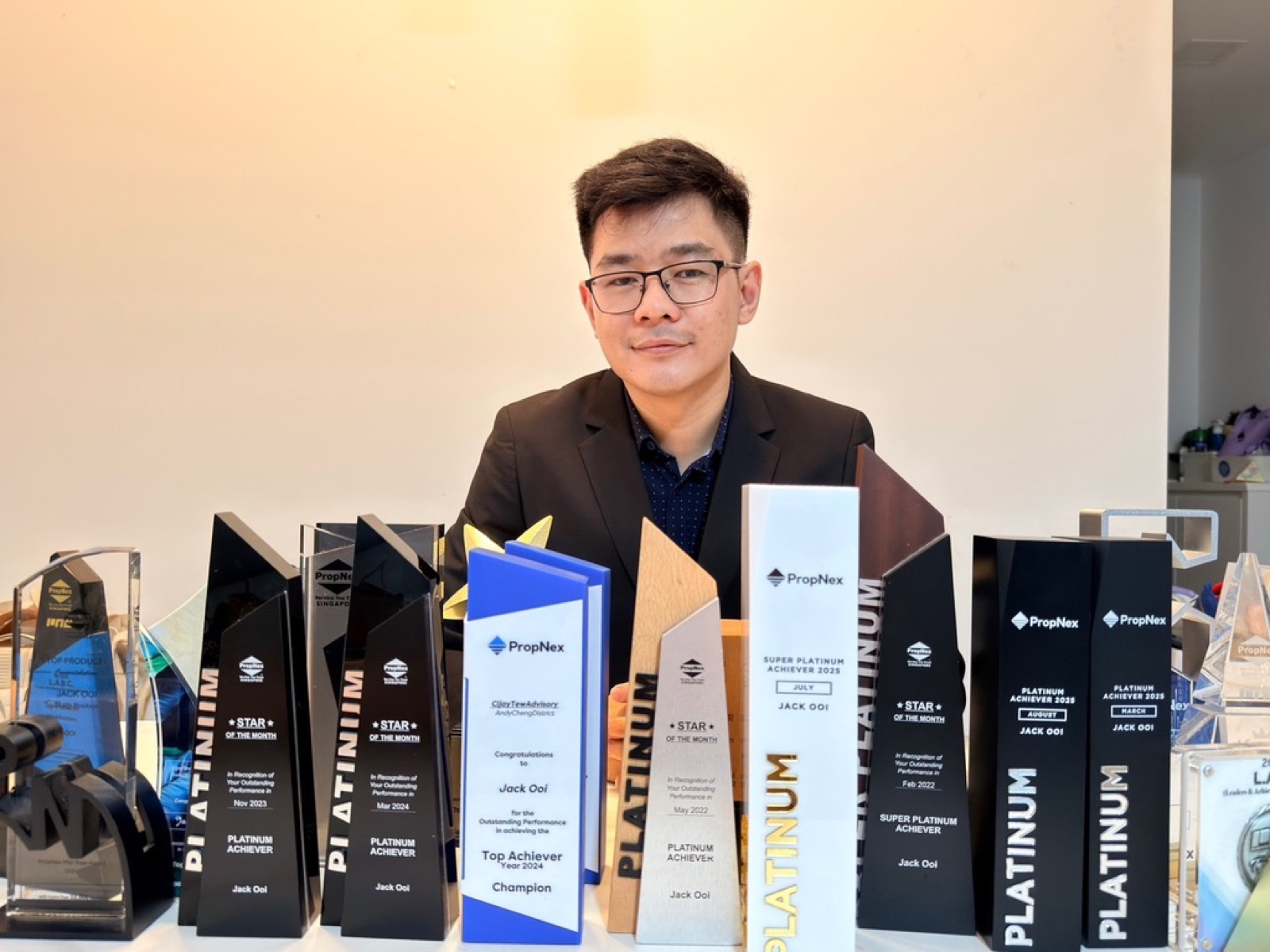 Jack Ooi with his collection of PropNex achievement awards